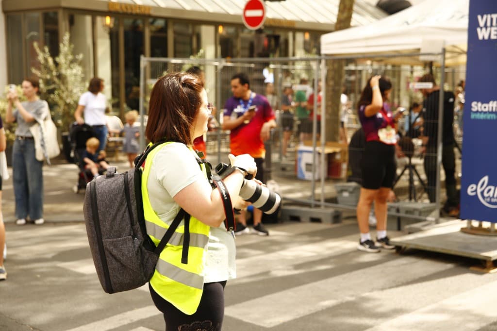 Photographe sportive avec appareil en bord de course