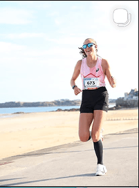 Coureuse souriante sur une promenade en bord de mer